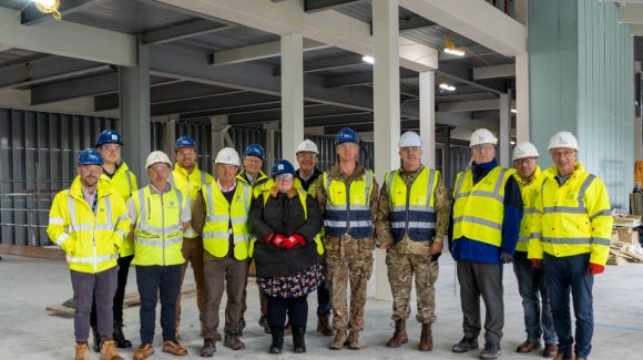 Representatives of Army Infrastructure and the Armoured Cavalry programme (centre), the DIO (right) and Aspire Defence (left), inside the Ajax facility under construction at Warminster Garrison. Copyright: Aspire Media Services.